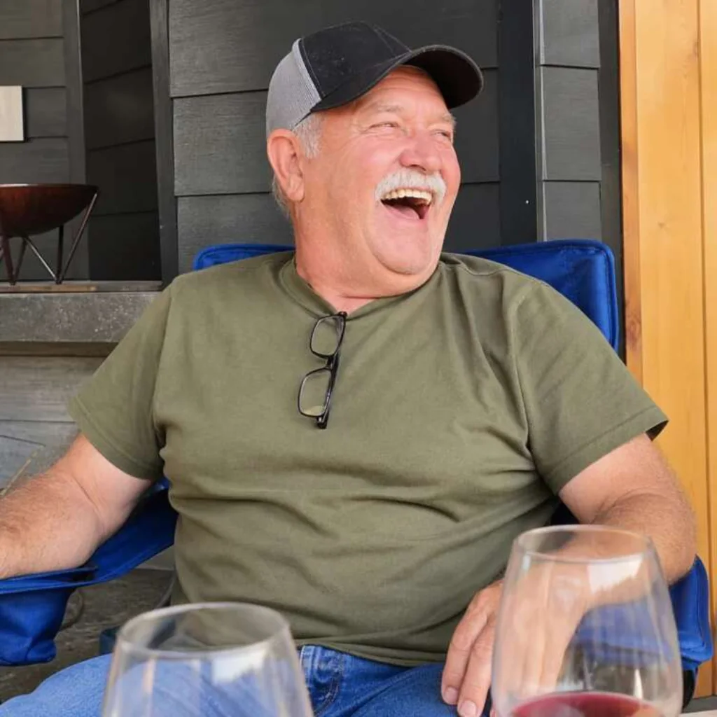 Older man laughing freely on a patio