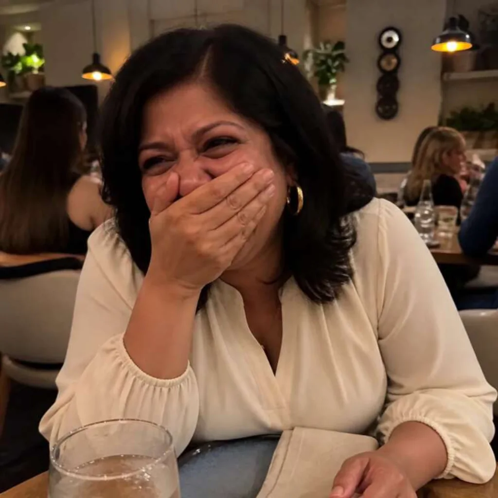 Woman laughing at a restaurant table